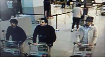 Two suspects were wearing identical dark clothes and gloved left hands, while the third, to their left, dressed in lighter clothing and a hat is suspected of fleeing the airport